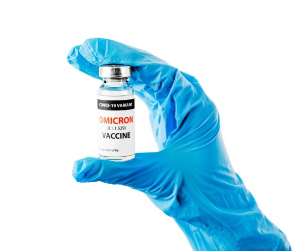 hand with surgical glove holding vial of omicron-targeting COVID vaccine