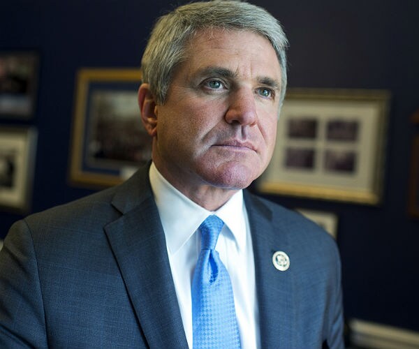 michael mccaul stands and listens to a media question