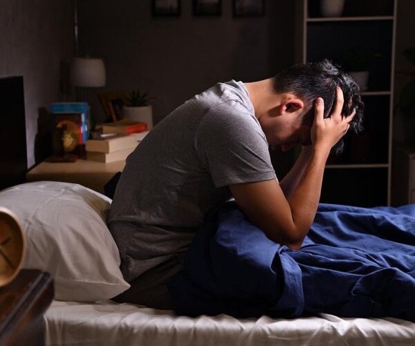man in bed feeling depressed
