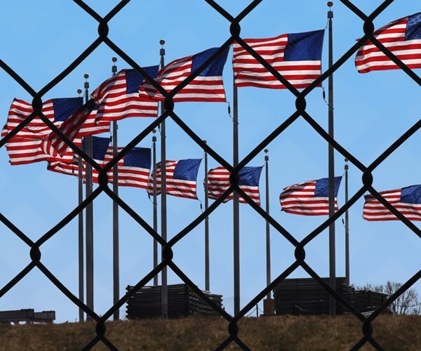 american flags behind chainlink fence