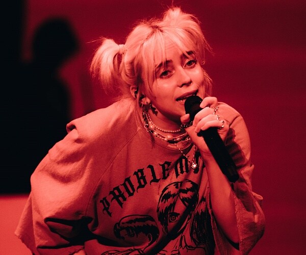billie eilish sings into mic onstage