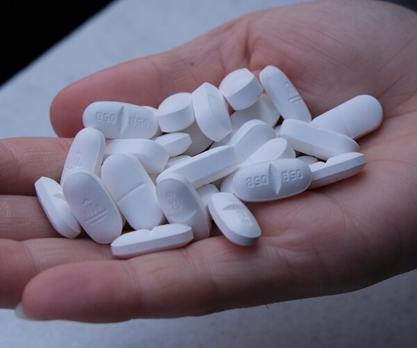 hand holding white pills