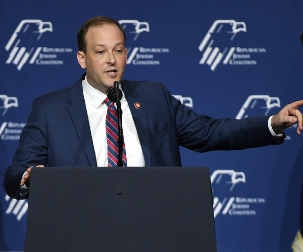 miller in a navy blue suit and red and blue striped tie