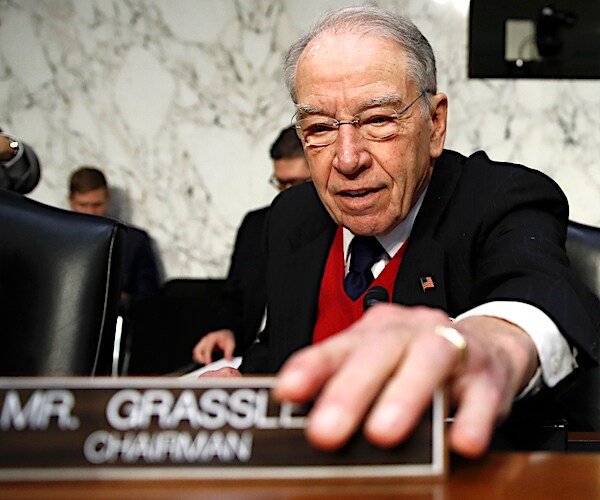 chuck grassley adjusts his nameplate in the senate