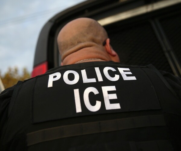 ice agent with police ice on the back of his uniform being shown