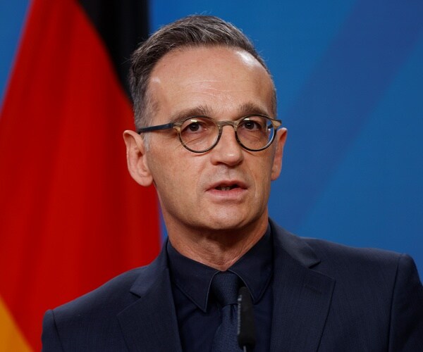 heiko maas sits onstage