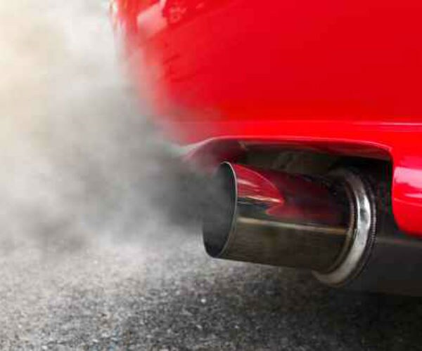 photo shows heavy, thick and gray looking exhaust fumes from a red vehicle 