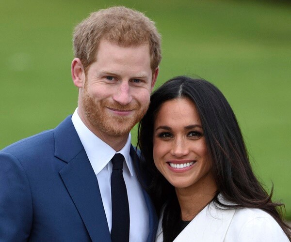 prince harry and meghan markle pose for a picture.