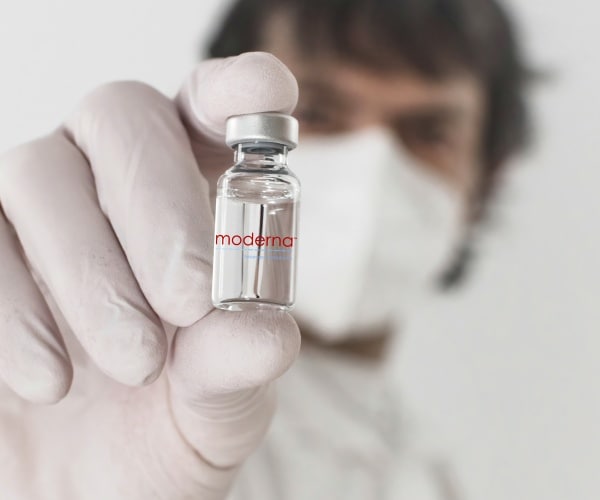 hold up vial of Moderna flu vaccine