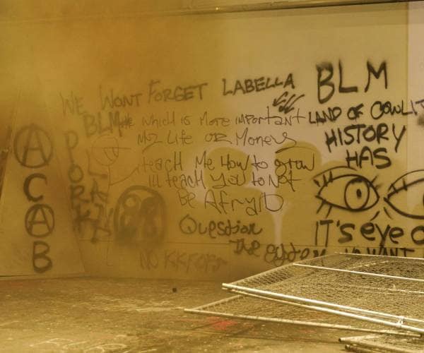 grafitti on the wall as a smoke bomb goes off