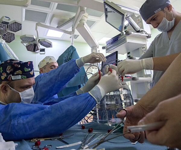 a team of surgeons and nurses operate in an operating room