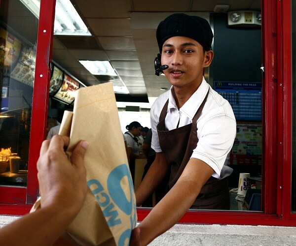 young man works in fast food window
