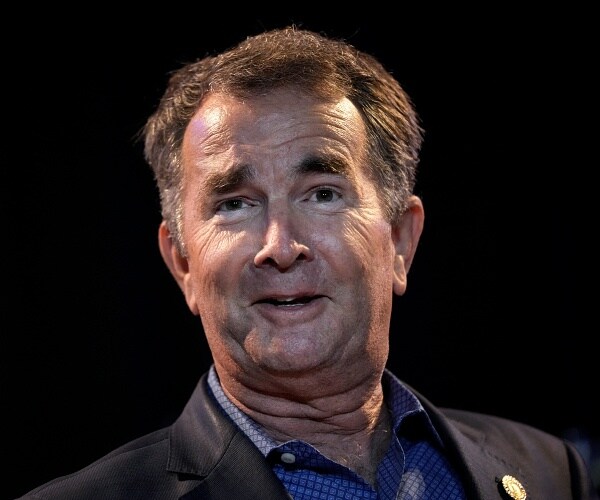 ralph northam stands onstage