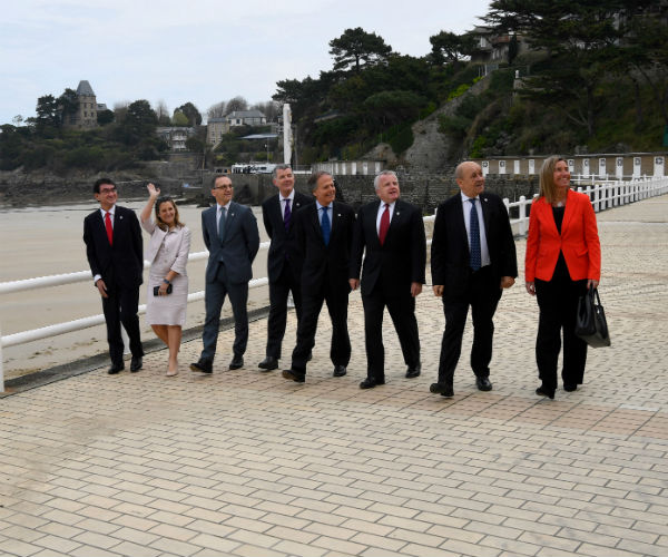 the ministers walk along a beach