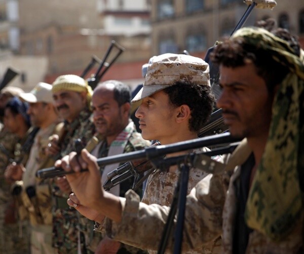 houthi rebel fighters carry weapons
