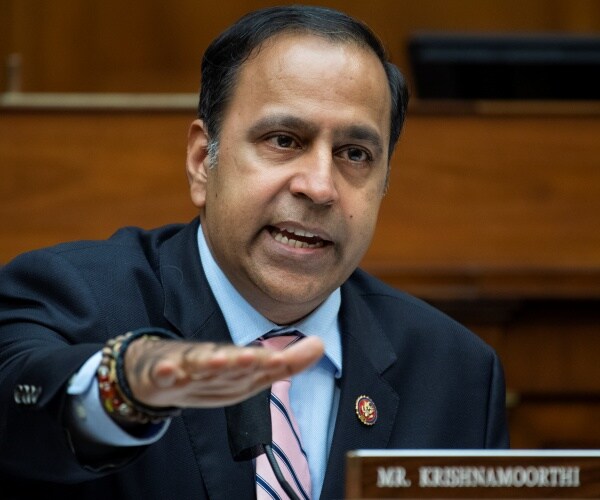 krishnamoorthi in a suit and striped pink tie