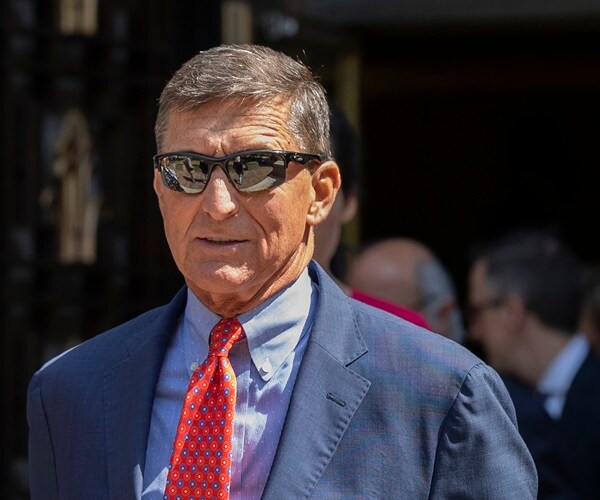 Michael Flynn leaves a federal court with dark sunglasses on