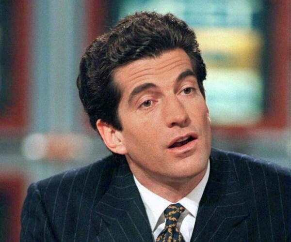 jfk jr in a striped navy blue suit and stripy tie