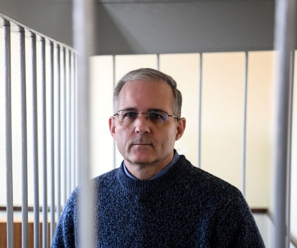 Paul Whelan stands inside a defendants' cage during a hearing.