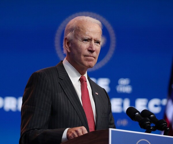 joe biden stands behind podium