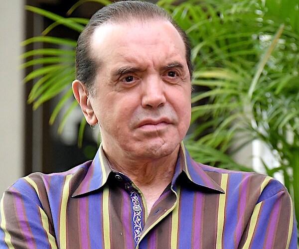 chazz palminteri sits on stage during a forum