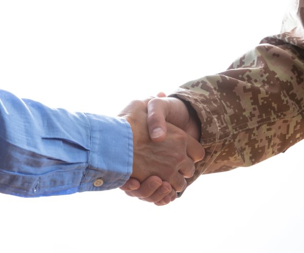 civilian shaking hands with military member