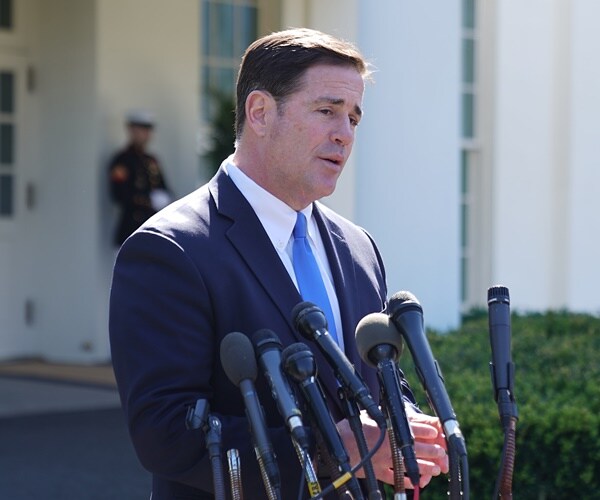 doug ducey stands at mics speaking to reporters