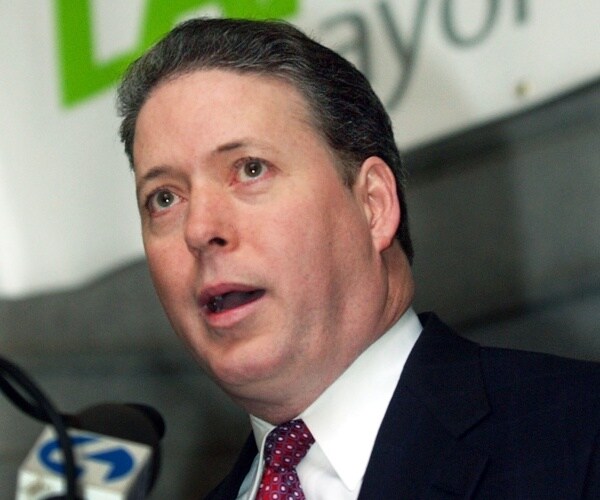 lamb speaking in a red and white polka dotted tie and black suit