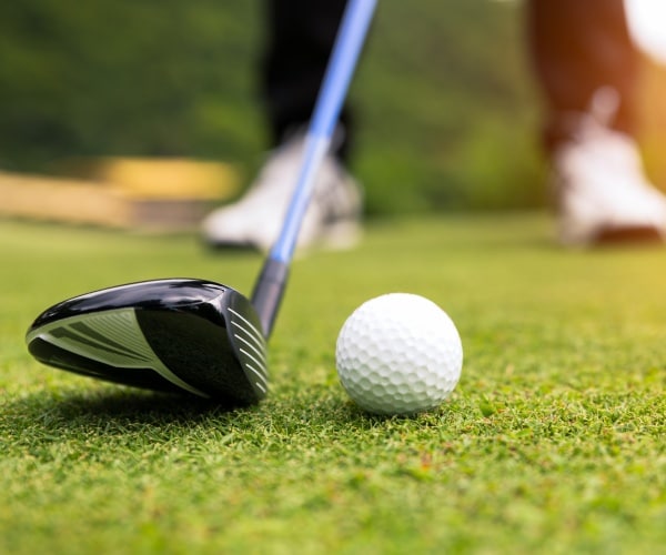 golf ball is shown with a man holding a club 