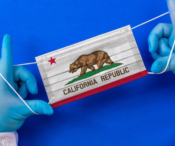 gloved hands holding a mask with a california republic flag on it