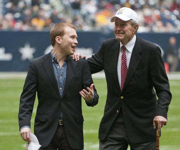 Former President George H.W. Bush leaves the field with the help of Pierce Bush, his grandson in 2009