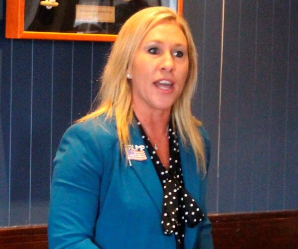 greene in a blue jacket and black and white polka dotted shirt