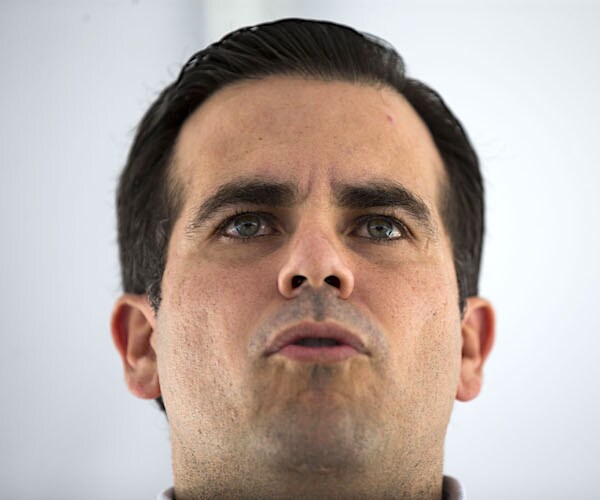 ricardo rosselló looks up as he speaks to the media