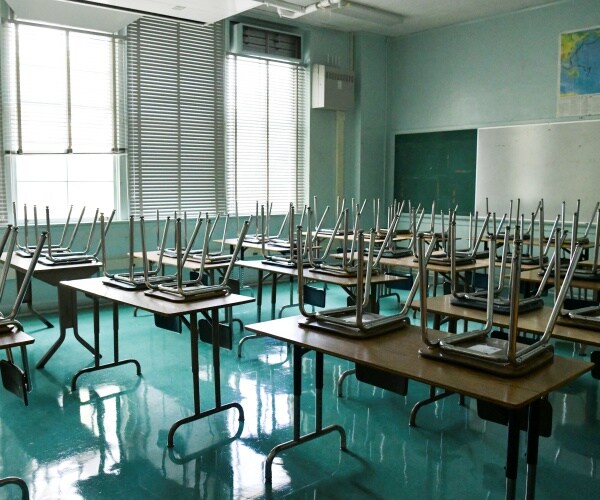 empty classroom with chairs stacked on desks