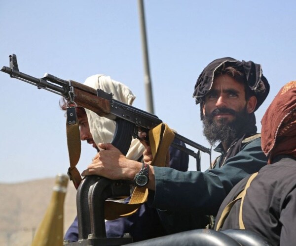 taliban fighters stand guard in a vehicle along the roadside in kabul 