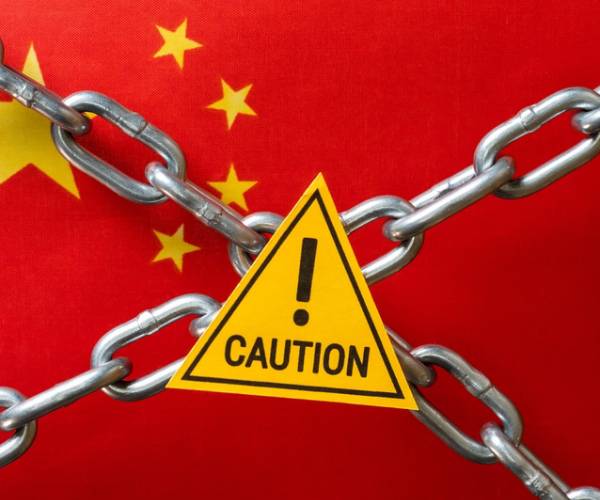 chinese flag with chains and a caution sign on top
