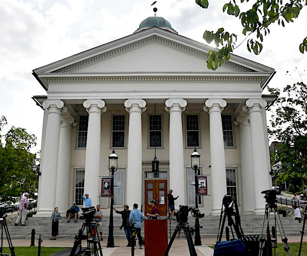 a scene from a picturesque college campus with a white pillared building