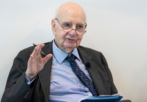 paul volcker speaks sitting in a chair