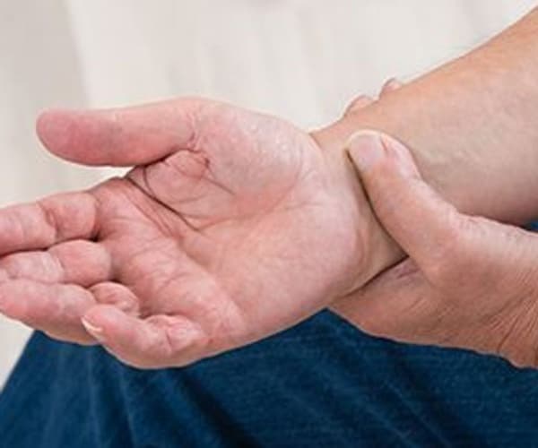 close up of man's hand holding the wrist of the other hand