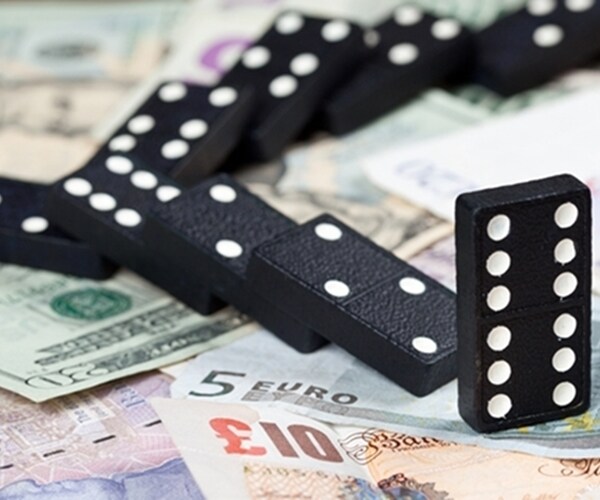 dominoes falling on american currency spread