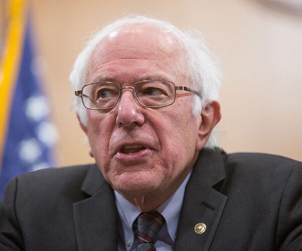 sen. bernie sanders is shown with the us flag in the background over his right shoulder