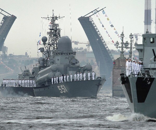 warships float past the dvortsovy (palace) drawbridge rising above the neva river.