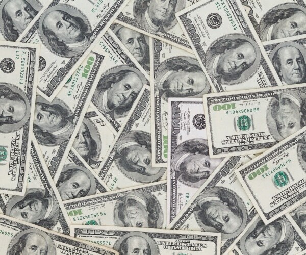 Hundreds of new Benjamin Franklin 100 dollar bills arranged randomly financial and monetary background