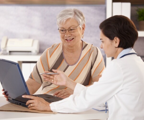 doctor and patient talking, looking at computer screen