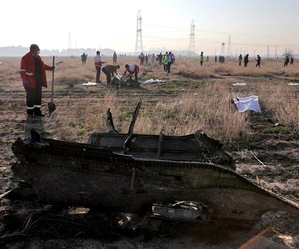 workers look through wreckage from a ukrainian jet crash in tehran