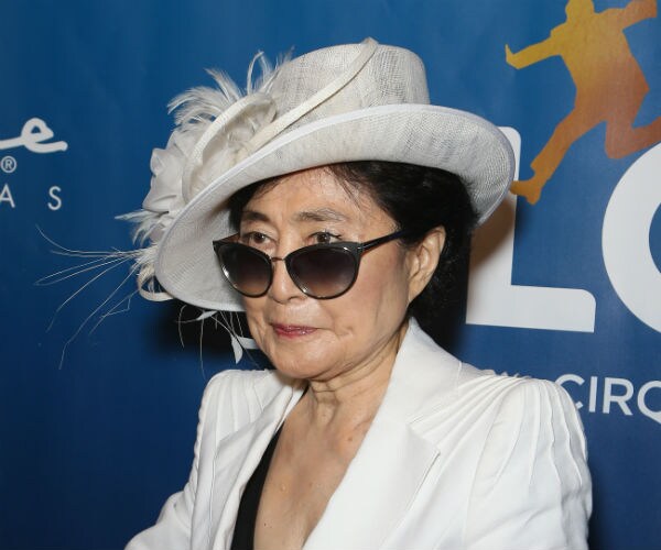 yoko ono is shown in ecru hat and suit with a black camisole