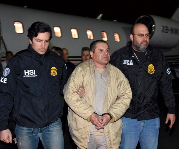 law enforcement escorts joaquin guzman off a plane and into united states custody