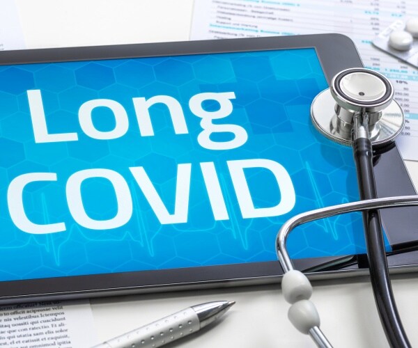 tablet says Long COVID, stethoscope, pills