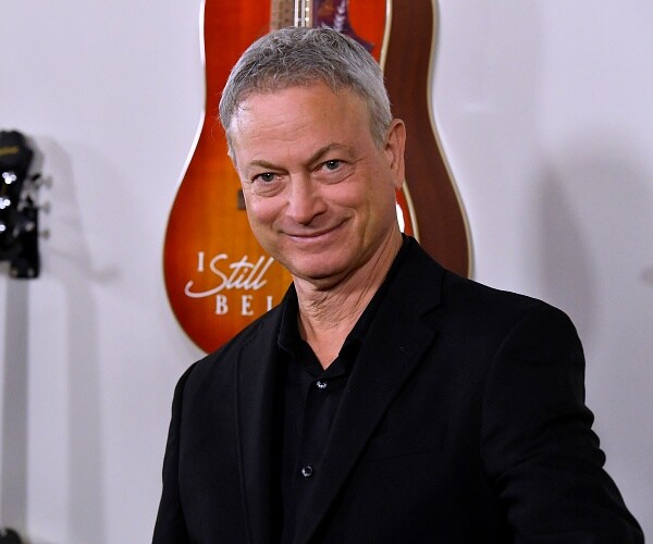 gary sinise stands on red carpet
