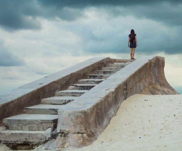 a young woman standing at the top of stairs leading to nowhere